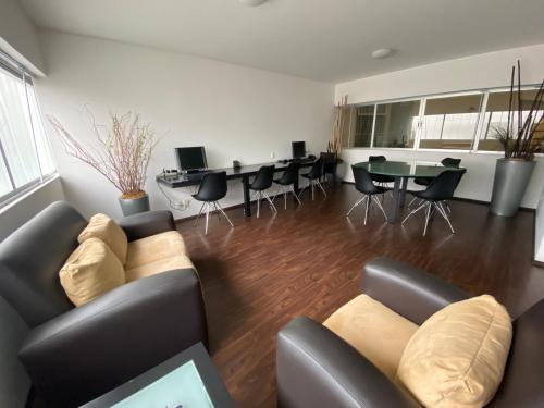a living room with a couch and a table and chairs at Suites Teca Once in Mexico City