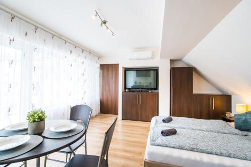 een woonkamer met een tafel en een televisie bij Siesta Sziget - Balaton-parti Apartmanok in Siófok