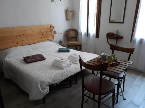 1 dormitorio con 1 cama, mesa y sillas en Come una volta en Monte Isola