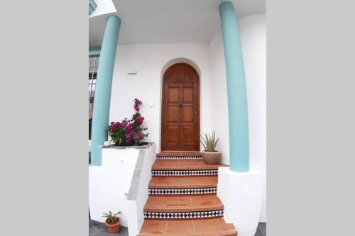 eine Treppe, die zu einer Tür in einem Haus führt in der Unterkunft CASA DE DISEÑO EN LA PLAYA. in Rota