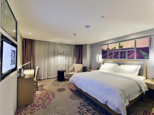 a hotel room with a large bed and a flat screen tv at Lavande Hotel Xining Haihu New District Wanda Plaza in Xining