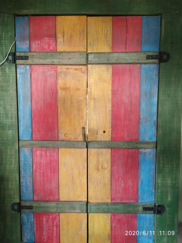 a wooden door with red and blue at Pousada Quintal Verde Floripa in Florianópolis