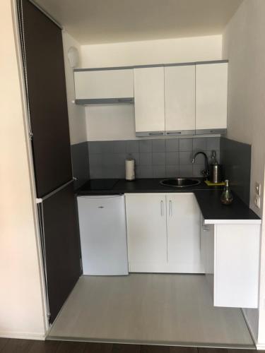 une petite cuisine avec des armoires blanches et un évier dans l'établissement Sweety Nest 224, à Villers-sur-Mer