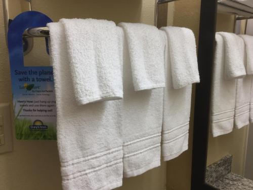 a group of towels hanging on a towel rack in a bathroom at Days Inn by Wyndham Simpsonville in Simpsonville