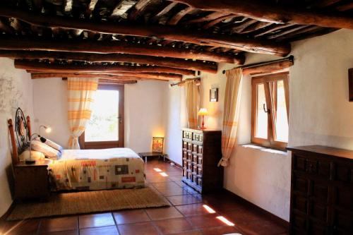 a bedroom with a bed and windows in a building at Cortijo Close in Busquístar