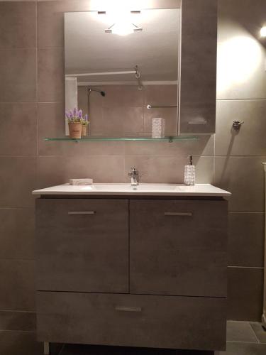a bathroom with a sink and a mirror at Harmony Apartment Kavala in Kavála