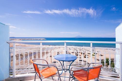 a table and chairs on a balcony with the beach at Hotel Ralitsa in Limenaria