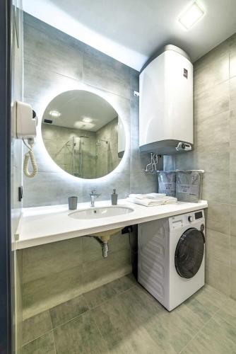 a bathroom with a sink and a washing machine at European Apart-Hotel, Most City Area in Dnipro