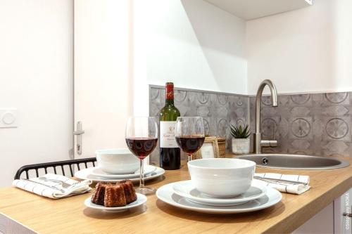 una mesa con dos copas de vino y pan en Life&Travel - Studio Cosy - Bordeaux Centre, en Burdeos