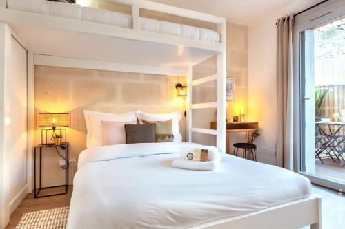une chambre avec un grand lit blanc et une fenêtre dans l'établissement Life&Travel - Studio Cosy - Parking - Terrasse, à Bordeaux