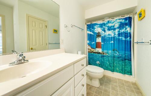 a bathroom with a sink and a lighthouse shower curtain at Ocean View's in Kill Devil Hills