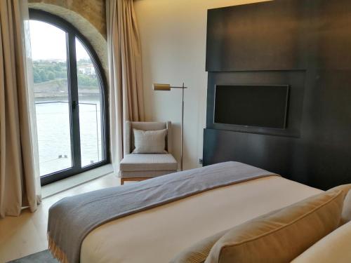 a bedroom with a bed and a tv and a window at NEYA Porto Hotel in Porto