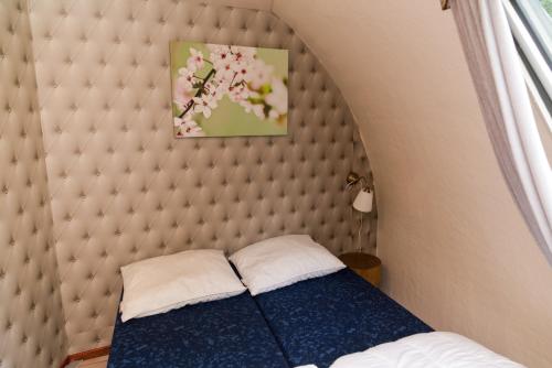 Bett in einem Zimmer mit gepolstertem Kopfteil in der Unterkunft Iglo Bungalow 26 in Chaam