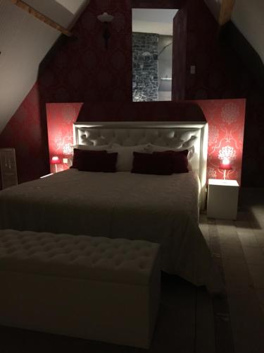 a bedroom with a large white bed with red walls at Ferme Delgueule in Tournai