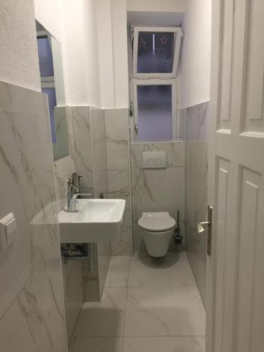 Gästezimmer Hozici في لينداو: حمام أبيض مع حوض ومرحاض