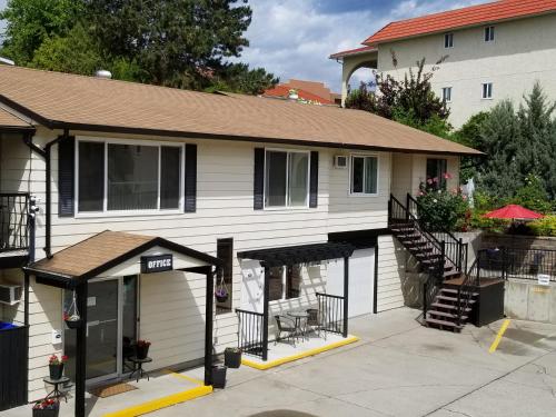 a white house with a porch and a patio at Lakeview Motel & Suites in Osoyoos