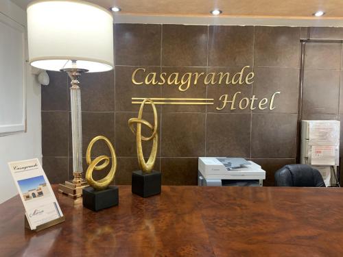 a table with a lamp and a sign that readsassociate hotel at Casagrande Hotel in Monclova
