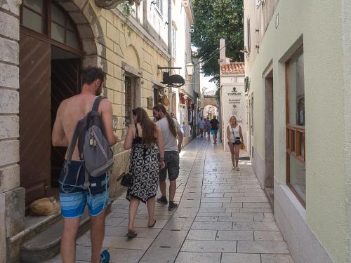 a group of people walking down a street at Zupan 1 - apartman in Krk