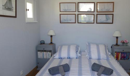 um quarto com uma cama com duas almofadas em La Passerose jardin clos 300mplage la Couarde sur mer em La Couarde-sur-Mer