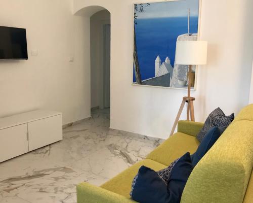 a living room with a couch and a tv at Beach apartments Isola d'Elba in Portoferraio