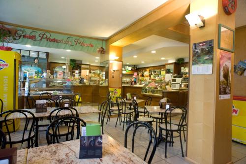jadalnia ze stołami i krzesłami w restauracji w obiekcie Hotel Blanchetti w mieście Ceresole Reale