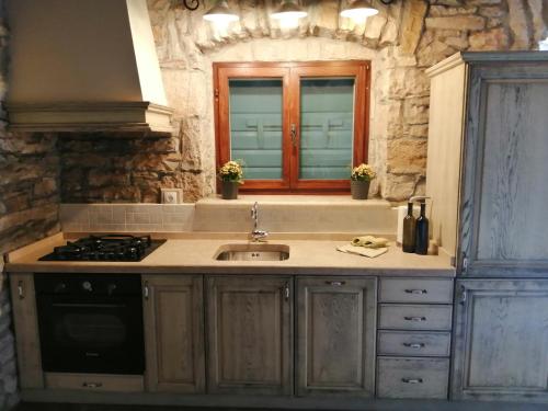 a kitchen with a sink and a stove and a window at Villa Viktor in Labin