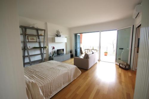 a white bedroom with a bed and a living room at LOFT BAYVIEW in Imperia