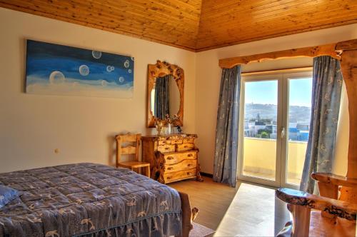a bedroom with a bed and a large window at Rancho Mar à Vista in Atalaia de Cima