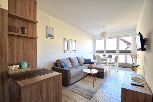 uma sala de estar com um sofá e uma mesa em Apartamenty NK em Mielno