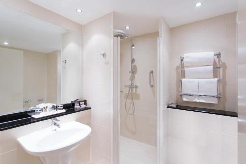 a white bathroom with a sink and a shower at Mercure Sheffield St Paul's Hotel & Spa in Sheffield