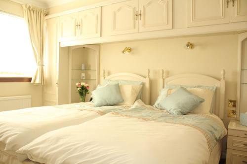 a bedroom with a large white bed with pillows at Abbots Way in Ayr