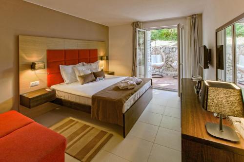 a hotel room with a bed and a balcony at TUI Blue Kalamota Island - All Inclusive in Dubrovnik