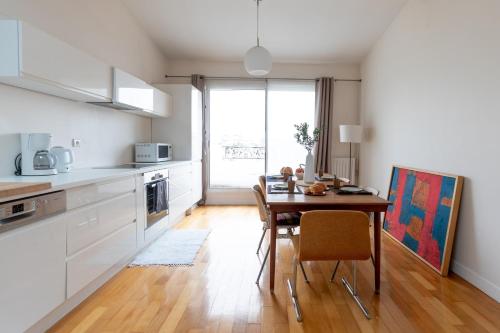 a kitchen with a wooden table and a dining room at Paris-Maison-appartement-7 chambres métro Jourdain in Paris