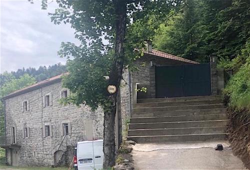 RieutordにあるGite en Ardèche en face de la rivièreの門と階段の木の隣の建物