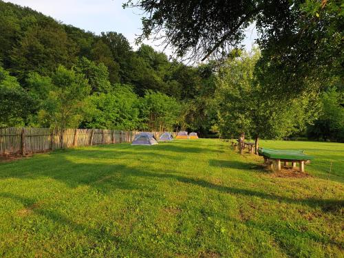 a park with tents and a bench in the grass at Casutele din Grosi in Groşi