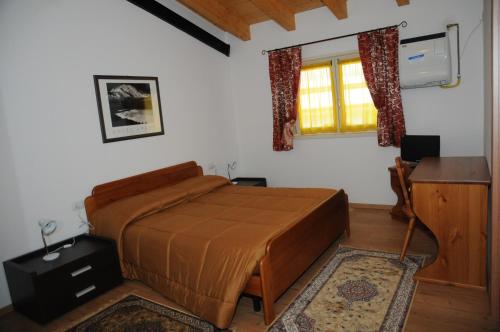 sypialnia z łóżkiem, biurkiem i oknem w obiekcie Affittacamere Dormire Caldi w mieście Trichiana