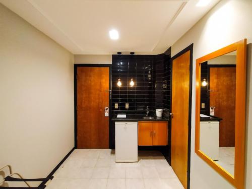 a small kitchen with a black tiled wall at Savassi Village in Belo Horizonte