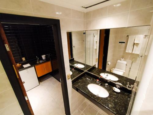 a bathroom with two sinks and a mirror at Savassi Village in Belo Horizonte
