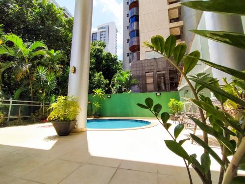 a swimming pool in the middle of a green fence at Savassi Village in Belo Horizonte