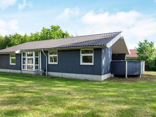 a small blue house with a large yard at 7 person holiday home in Hemmet in Falen