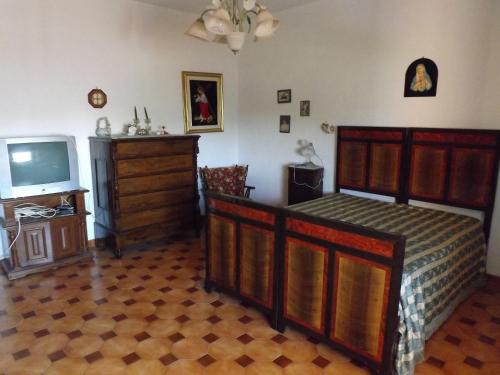 a bedroom with a bed and a tv and a dresser at nena in Diso