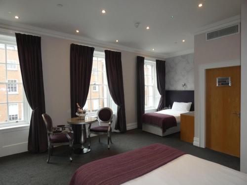 una camera d'albergo con letto, tavolo e sedie di Jackson Court Hotel a Dublino