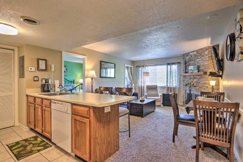 a kitchen and living room with a table and chairs at Condo with Pool and Grill Access about 4 Mi to Gatlinburg! in Gatlinburg