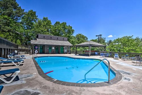 a swimming pool with chairs and a building at Condo with Pool and Grill Access about 4 Mi to Gatlinburg! in Gatlinburg