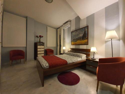 1 dormitorio con 1 cama, 2 sillas y mesa en Ático San Clemente en Sevilla