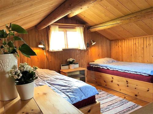 Villa Klockarbo - Stugor - Cabins في تالبيرغ: غرفة نوم بسرير في كابينة خشبية
