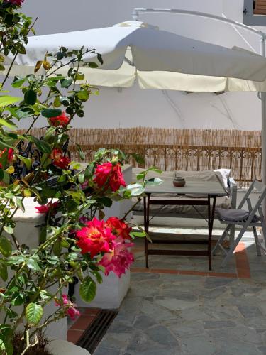 a white tent with a table and flowers on a patio at Dominik apartment in Patmos