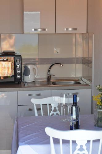 a kitchen with a sink and a table with a bottle of wine at Rubin Jelsa in Jelsa