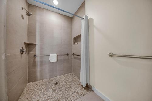 a bathroom with a shower with a shower curtain at Peninsula Island Resort & Spa - Beach front Property at South Padre Island in South Padre Island