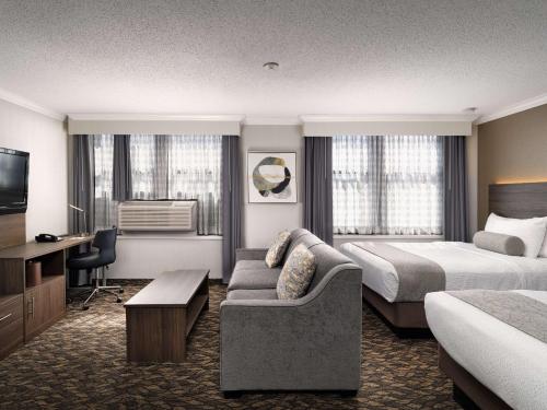 Habitación de hotel con 2 camas y sofá en BEST WESTERN PLUS Carlton Plaza Hotel en Victoria